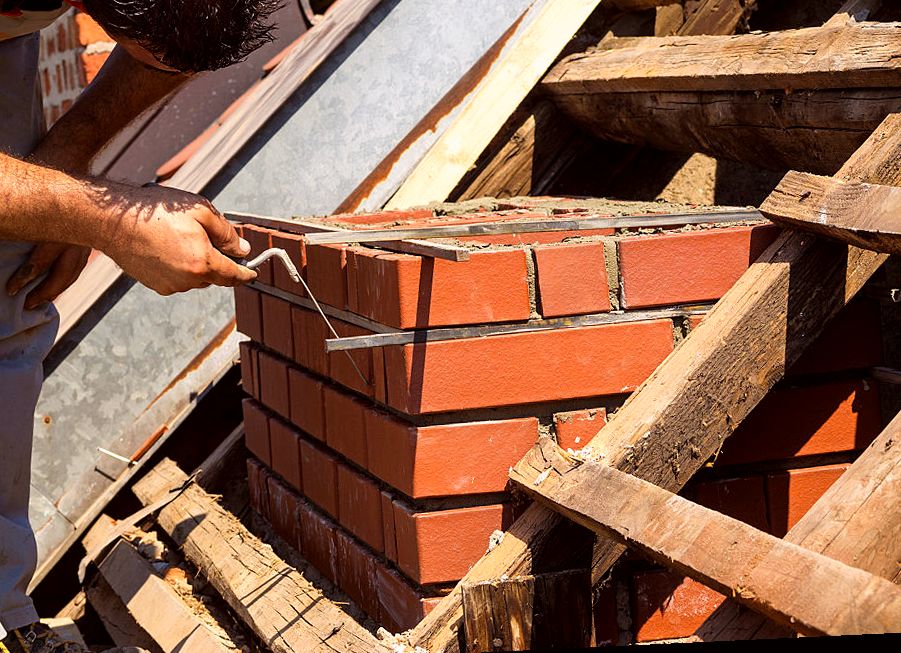 Mason laying brick courses for a rebuilt Glendora chimney